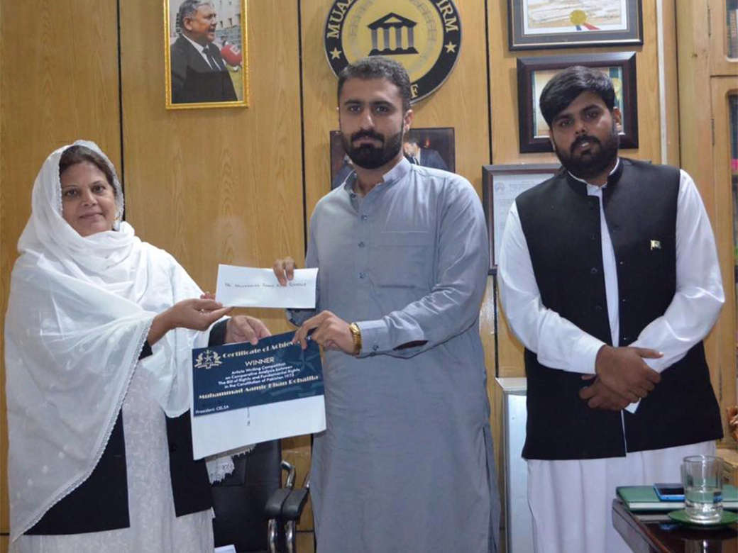 Mr. Muhammad Aamir Khan Rohailla receiving first prize from Mrs. Ummi-Farhat, Co-Chairperson, MLF. Facilitated by Mr. Israr Ahmed Durrani.